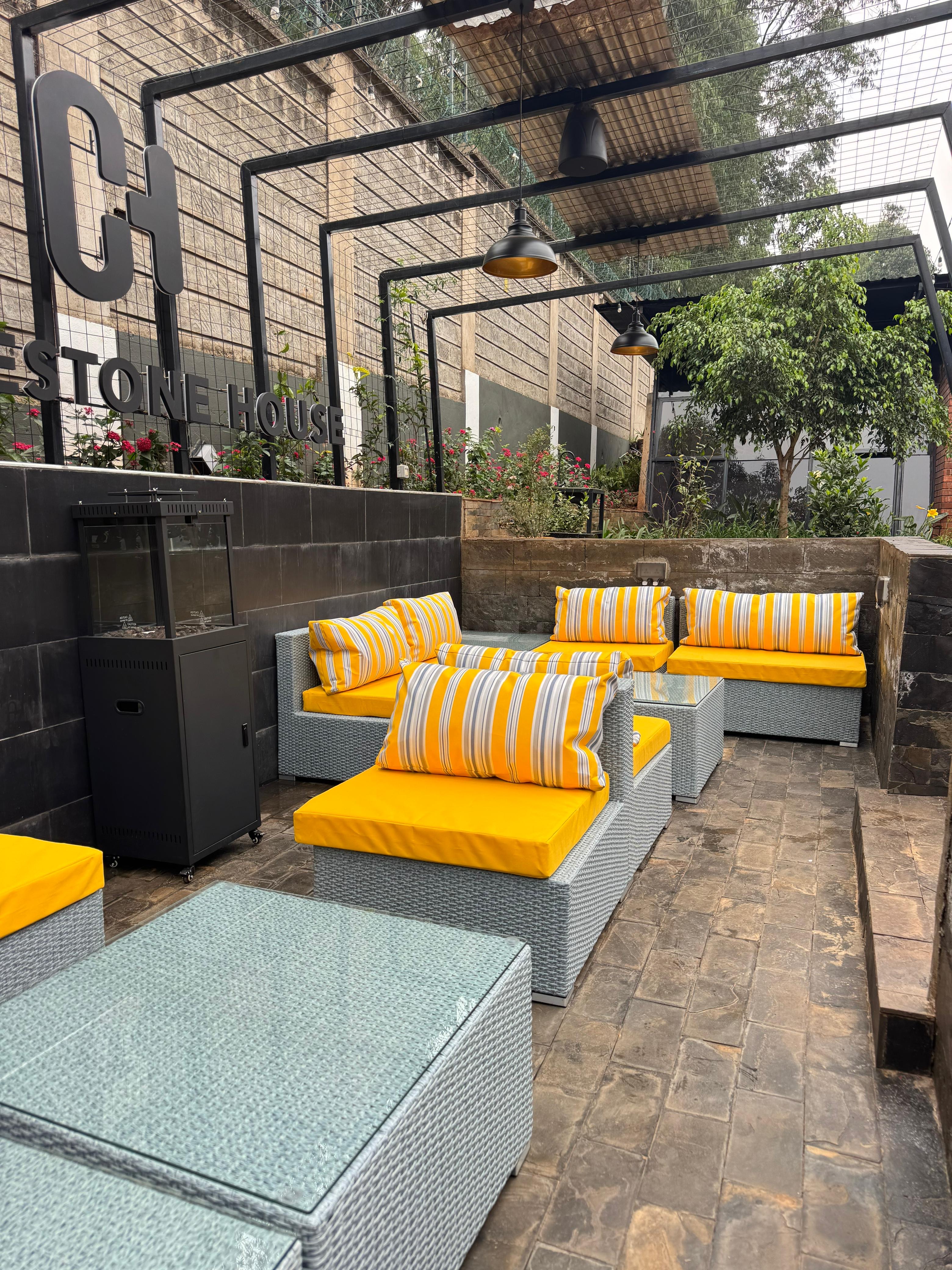 Sunlit garden terrace seating framed by the pergola and greenery